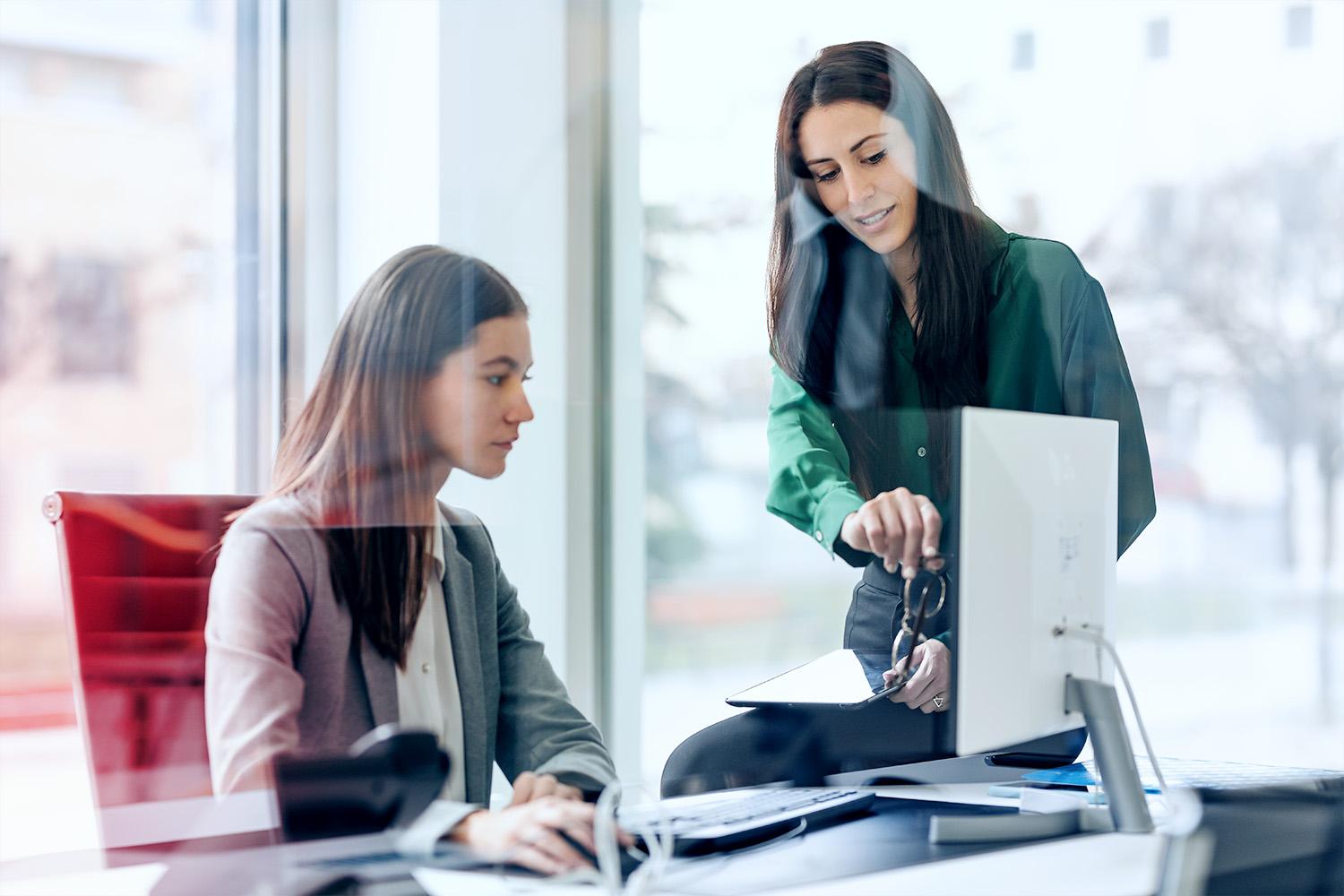 Zwei Kolleginnen im Büro beim auswerten von Daten